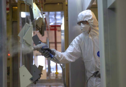 Powder coater at Terry Lifts painting the lift parts.