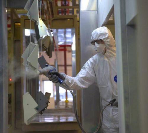 Powder coater at Terry Lifts painting the lift parts.